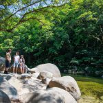 Visitors beside rainforest and granite boulders at Mossman Gorge