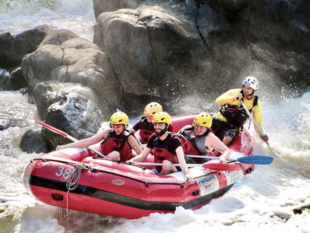 A guided rafting group paddling through rapids near Cairns