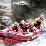 A guided rafting group paddling through rapids near Cairns