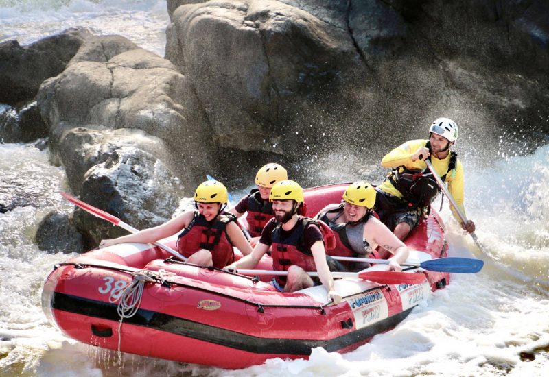 A guided rafting group paddling through rapids near Cairns