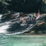 Visitors enjoying a waterfall swimming stop on a Cairns day tour
