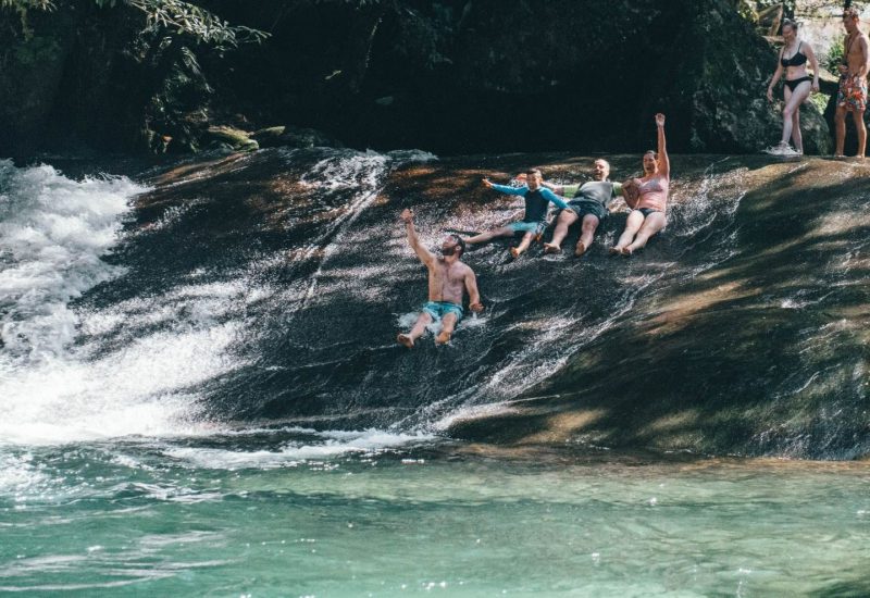Visitors enjoying a waterfall swimming stop on a Cairns day tour